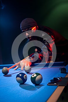 Man playing pool lining up on the cue ball