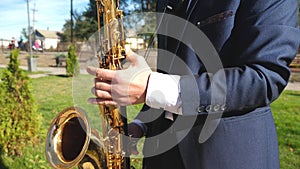 A man playing saxophone jazz music. Saxophonist in dinner jacket play on golden saxophone. Live performance.