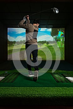 A man playing screen golf. Golf Simulator.