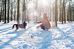 Man playing with siberian husky dog in snowy park