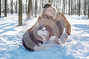 Man playing with siberian husky dog in snowy park