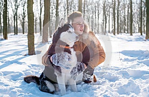 Man playing with siberian husky dog in snowy park