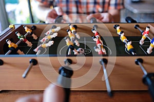 Man playing table football soccer game close up with his friends