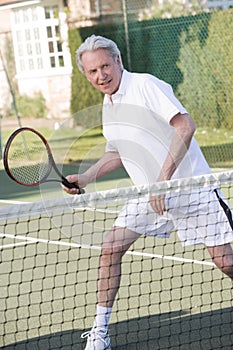 Man playing tennis and smiling