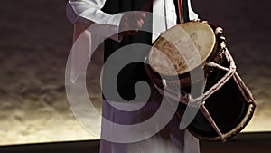 Man playing traditional Emirati drums percussion instrument, hands only in frame