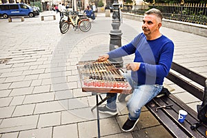Man playing traditional hammered dulcimer with mallets. Street artist plays songs on the Bucharest`s streets in downtown.