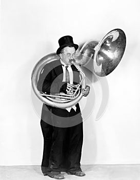 Man playing a tuba in a top hat photo