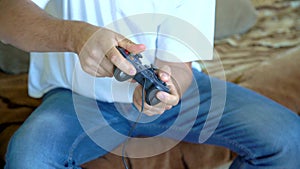 Man playing video game with a joystick. Close up of male hands holding a joystick controller while playing a video games