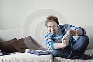 Man Playing Video Game On Sofa