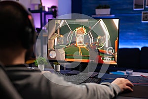 Man playing video games on computer with mousepad