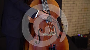 Man playing violoncello. Violinist male playing music. Musician at stage concert.