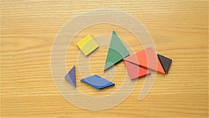 Man playing wooden tangram and making different shapes of human