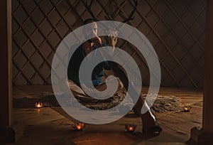 Man playng on didgeridoo by candlelight and tibetian bowl.