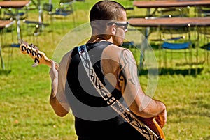 Man plays bass guitar outdoor
