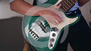 Man plays electric guitar changing chords and fingering strings with his fingers