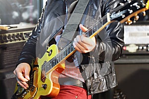 Man plays electric guitar in studio