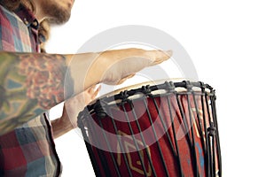 Man plays ethnic drum darbuka percussion, close up musician isolated on white studio background