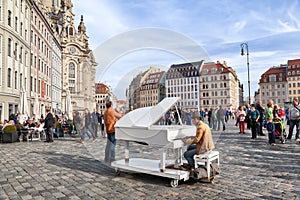 Man plays on a grand piano on Neumarkt square in Dresden