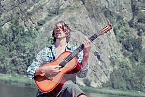 Man plays the guitar in nature