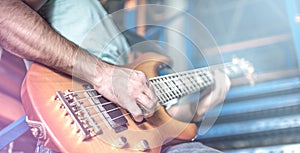 Man plays guitar on stage surrounded by light