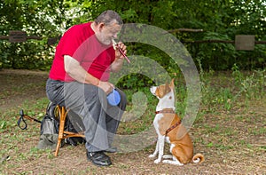 Man plays his basenji dog a melody with fife