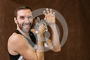 man plays with a kitten. Hugs him and kisses him
