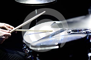 Man plays musical percussion instrument with sticks closeup on a black background, a musical concept with the working