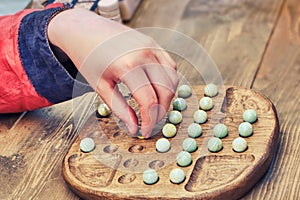 A man plays a retro board game Mill. An old intellectual game for two players