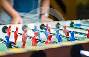 Man plays table football. Detail of man`s hands playing the kicker