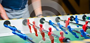 Man plays table football. Detail of man`s hands playing the kicker