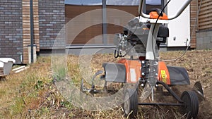 Man plow townhouse yard with cultivator. Preparing for lawn sow. Gimbal movement