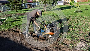 A man plowing a field cultivator, land