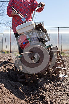 Man plowing   land with   cultivator