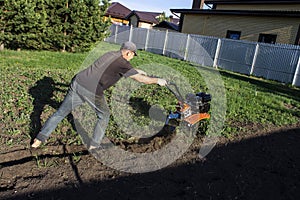 Man plowing land tillers, gardening and farming photo