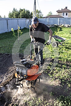 Man plowing land tillers, gardening and farming photo