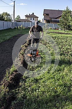 Man plowing land tillers, gardening and farming photo