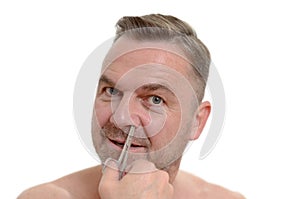 Man plucking his nose hairs with tweezers