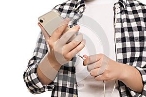Man plugging headphones to smartphone on white background, closeup