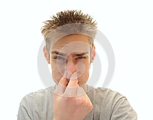 Man plugging his nose from odor