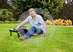 Man plugging laptop power into the ground