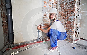 Man plumber installing heating system in apartment.