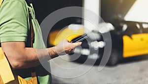 Man pointing finger on screen smartphone on background yellow taxi, tourist hipster using in hands mobile phone, person connect