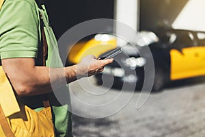 Man pointing finger on screen smartphone on background yellow taxi, tourist hipster using in hands mobile phone, person connect