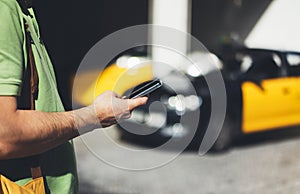 Man pointing finger on screen smartphone on background yellow taxi, tourist hipster using in hands mobile phone, person connect wi