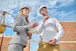 Man pointing hand up and looking woman