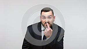 MAn pointing at his nose showing lie gesture.