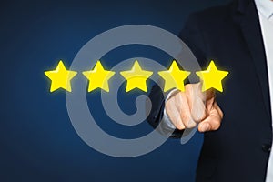 Man pointing at icons of five stars on blue background, closeup. Quality rating