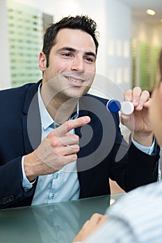 man pointing at lenses in optics