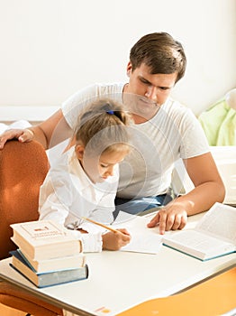 Man pointing on mistake at daughters notebook