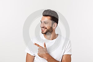 Man pointing showing copy space isolated on white background. Casual handsome Caucasian young man.